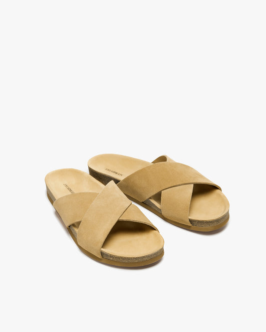 Solvik in sand suede showcases wide, cross-over suede straps and a contoured cork sole, creating a minimalist men’s sandal ideal for summer comfort and versatile styling.